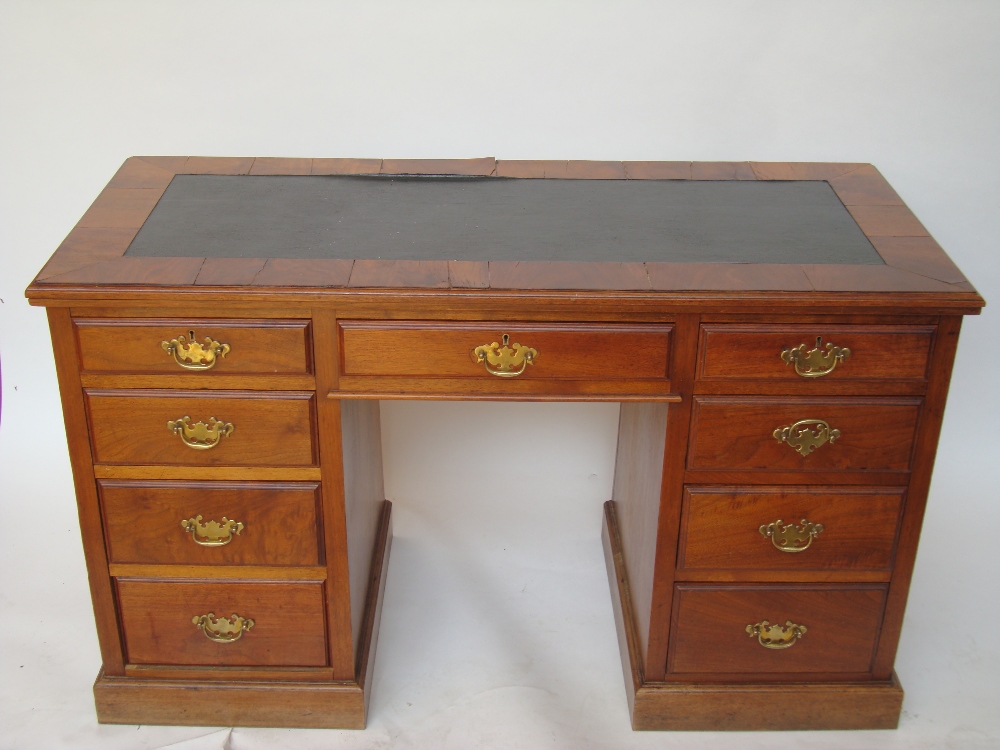 An Edwardian walnut twin pedestal desk, the rectangular top with moulded edge inset with green