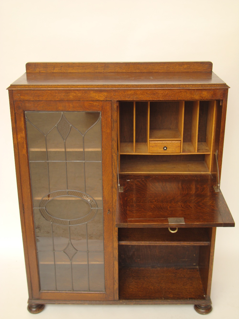 An early 20th Century oak bookcase with fall front secretaire.