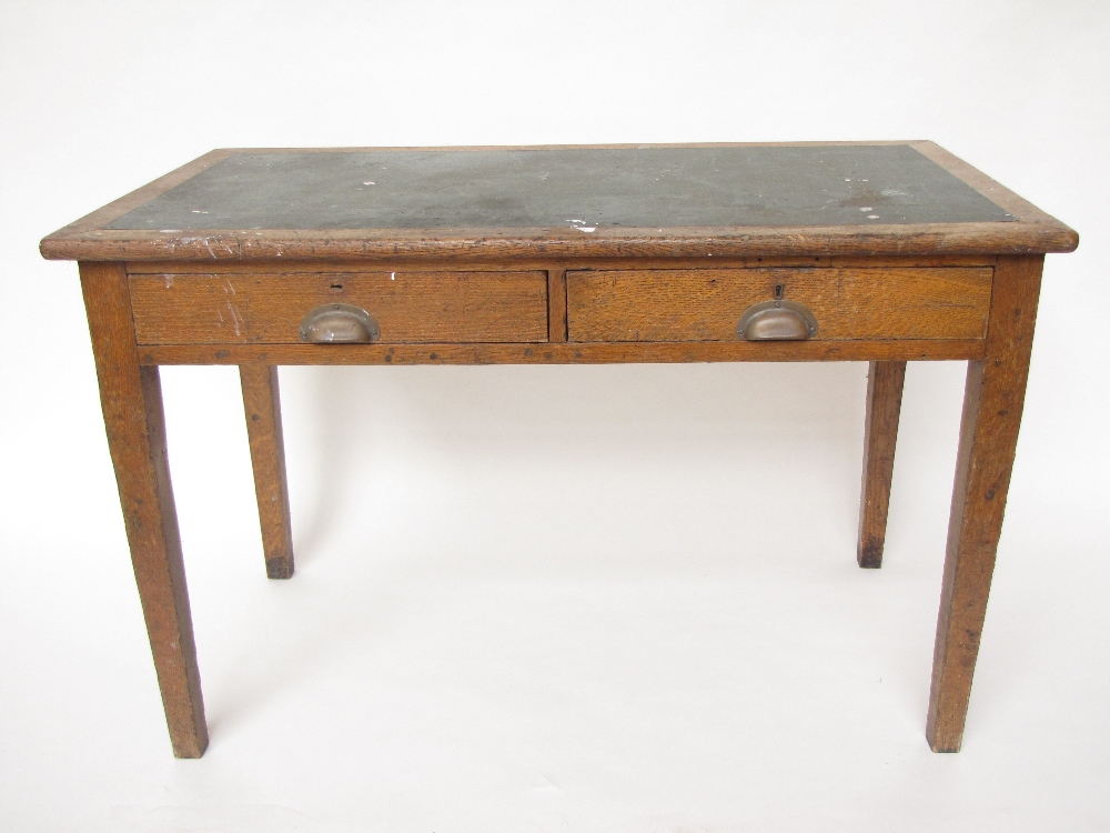 An Edwardian oak writing desk, the rectangular top inset with writing surface over two short