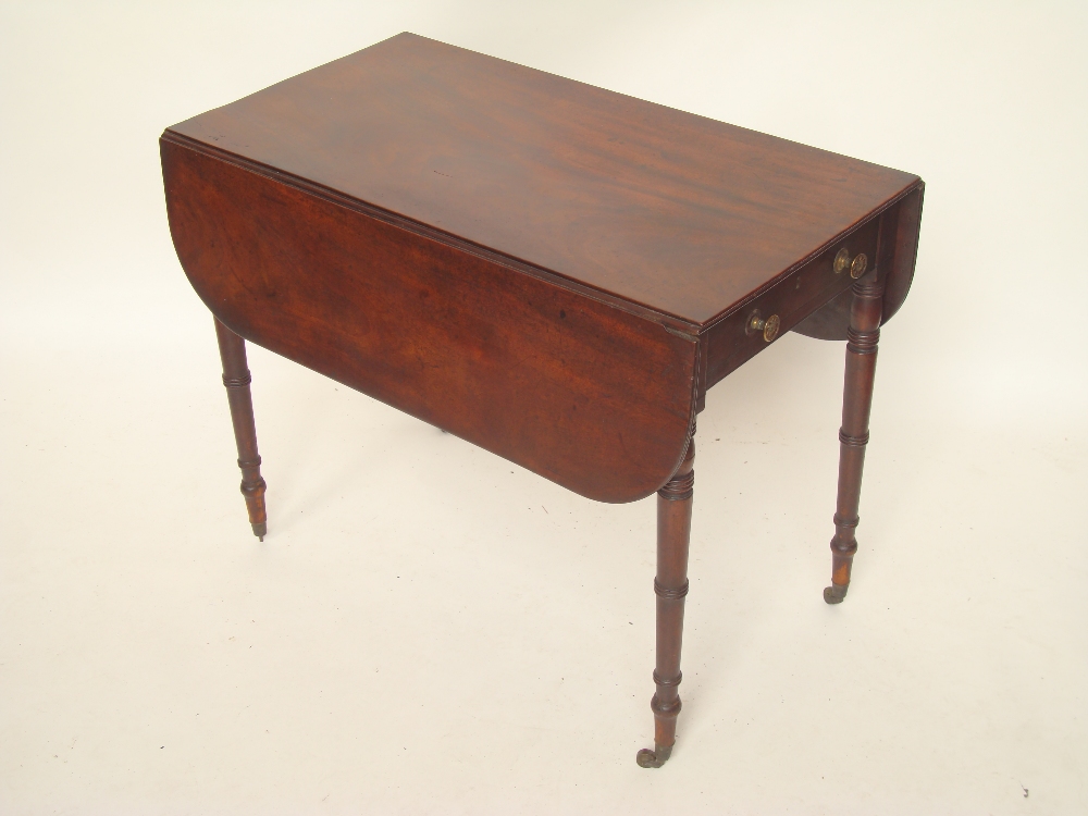 An early 19th Century mahogany Pembroke table, the top with twin hinged flaps and reeded edge over