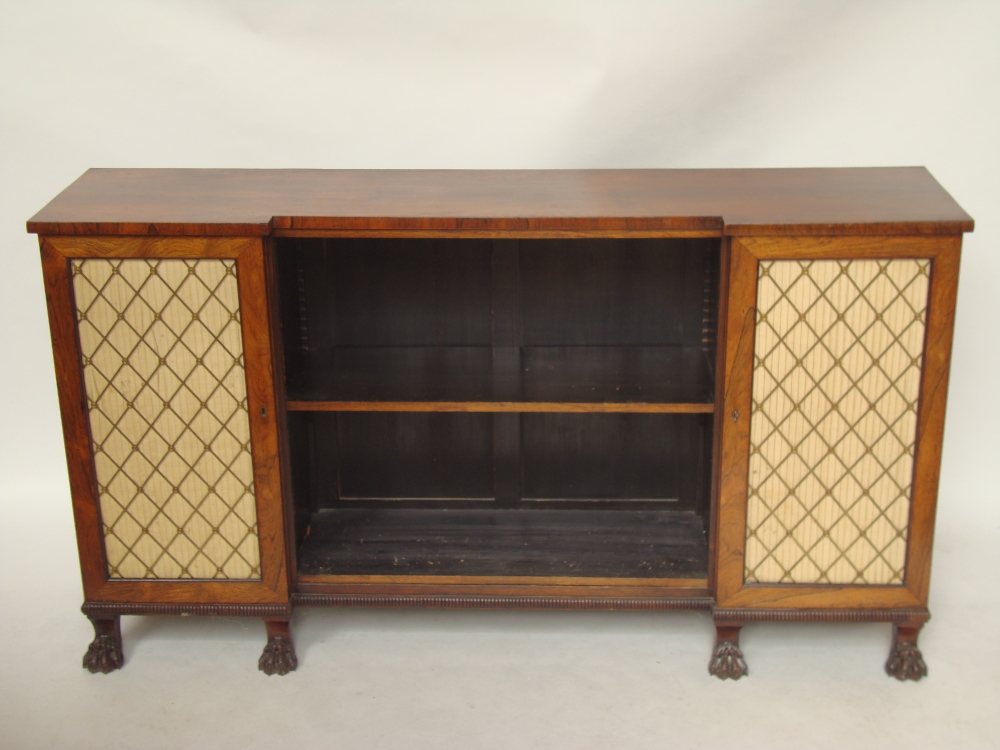 A Regency rosewood inverted breakfront bookcase cabinet, the top above a central open bookcase