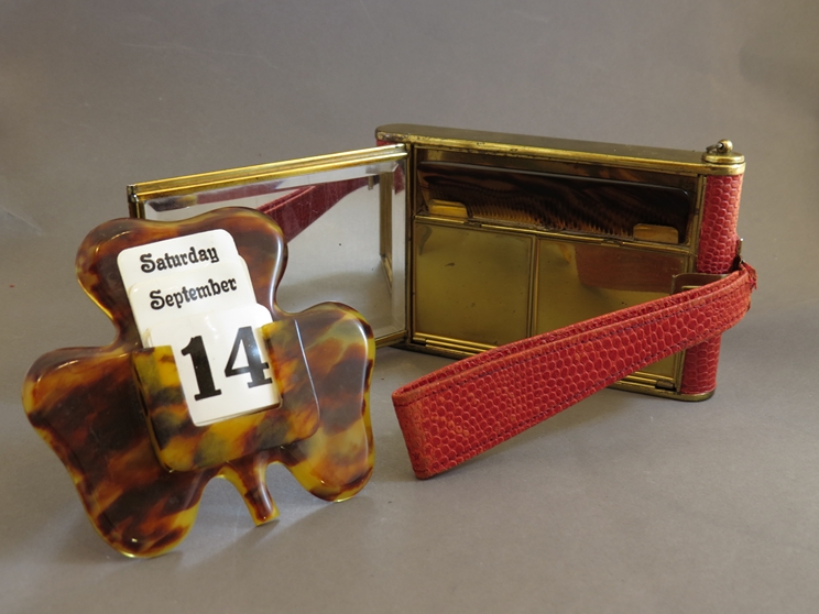 A clover leaf perpetual desk calendar, with a red snakeskin effect compact/cigarette case