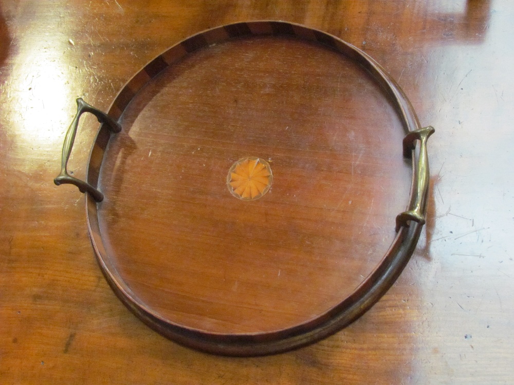 A circular mahogany brass handled drinks tray with inlay to sides and shell centre