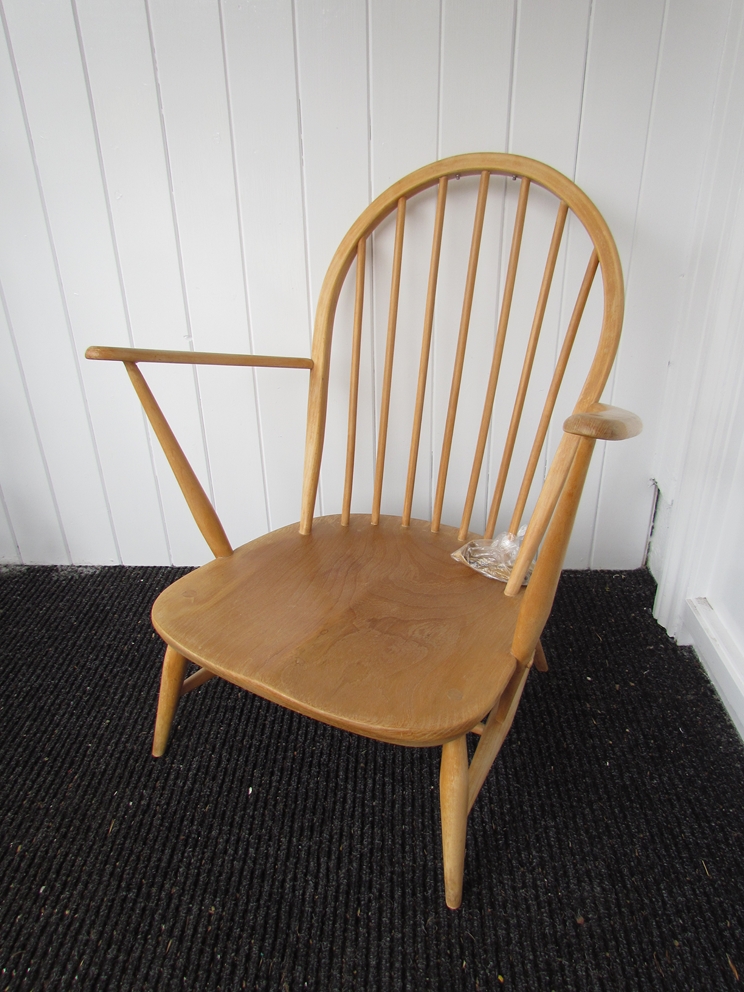An Ercol light elm finish low armchair with hooped stick back