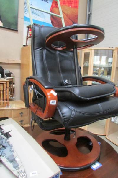 A black leather massage chair with stool