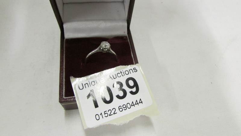 A diamond solitaire ring of approximately one quarter carat on a platinum? shank