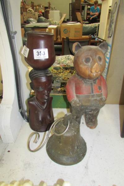 A wooden ethnic bust candleholder, a wooden bear and a brass bell