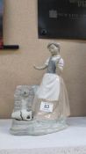A NAO figurine of lady by water pump