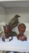 A pair of carved Indonesian busts and a carved bird signed 'Gustave Chery'