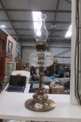 An oil lamp with brass column and base, glass font and chimney (no shade)