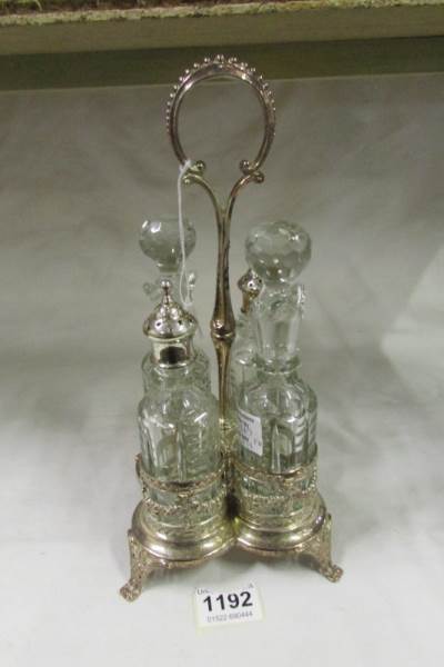 An ornate silver plated cruet stand with 4 bottles