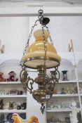 A hanging brass oil lamp with shade