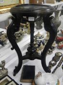 A carved dark wood pot stand