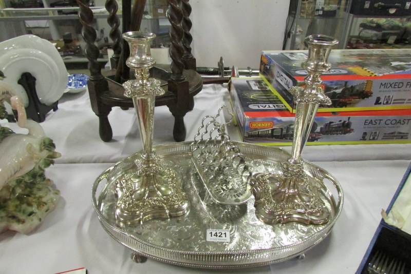 A silver plated gallery tray, pair of silver plated candlesticks and silver plated toast rack