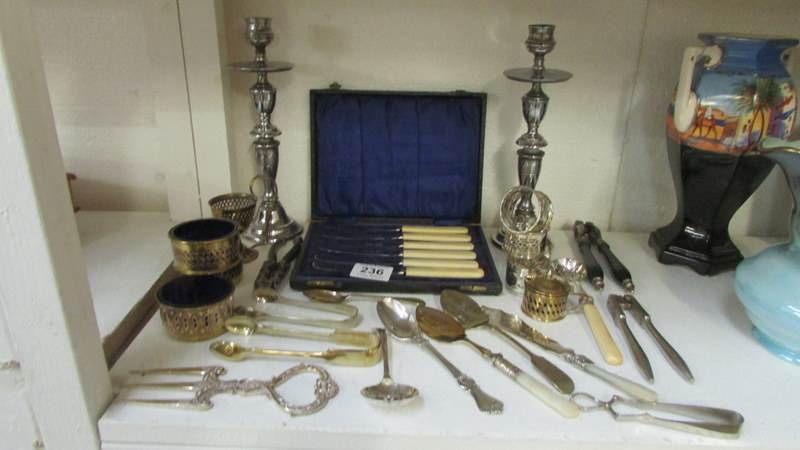 A mixed lot of silver plate including candlesticks, napkin rings, cutlery etc