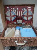 A wicker picnic basket complete with picnic set