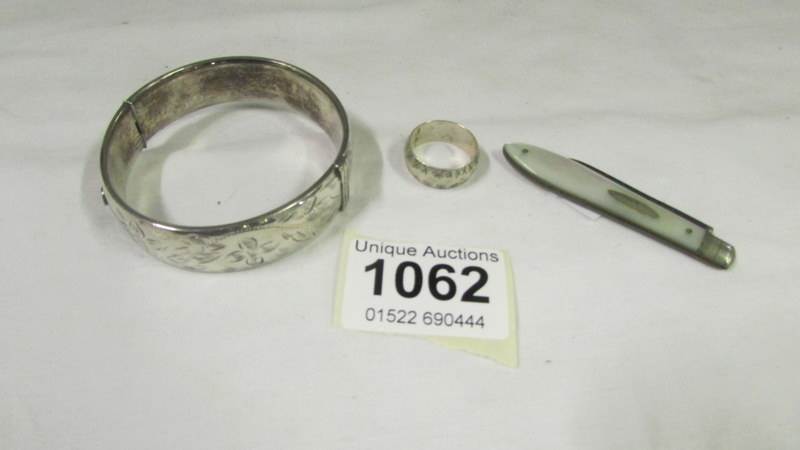 A silver bangle, silver and mother of pearl penknife and silver ring