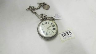 A silver pocket watch on chain and with fob