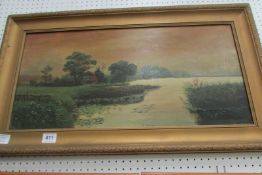 A gilt framed oil on canvas of a barn by a lake