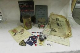 A box of cloth military badges, newspaper cuttings, old tobacco tins etc
