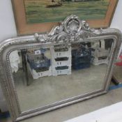 An overmantel mirror in silvered frame