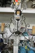 A wrought iron chandelier style wall light