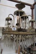 An old brass chandelier depicting chariots for restoration