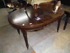 An oval mahogany dining table on reeded legs