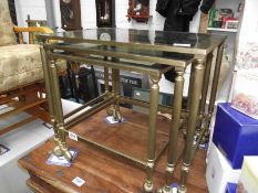 A nest of 3 brass tables