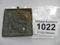 An early bronze plaque with raised relief showing soldier raising weapon for attack, 5cm x 4.5cm