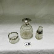 A large scent bottle (missing stopper), a small scent bottle and a glass salt all with silver