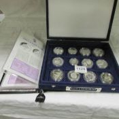 A cased set of 12 silver coins depicting ships with certificates