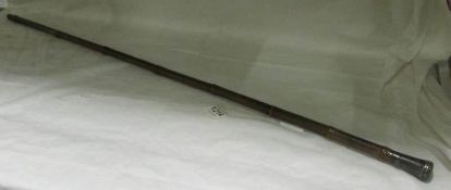 A  bamboo walking stick with silver top containing secret compartment