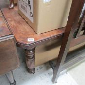 A mahogany extending table on heavy reeded legs