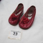 A pair of small red leather shoes suitable for a doll