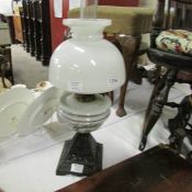 An oil lamp with glass font complete with shade