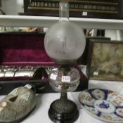 An oil lamp complete with acid etched shade and glass chimney