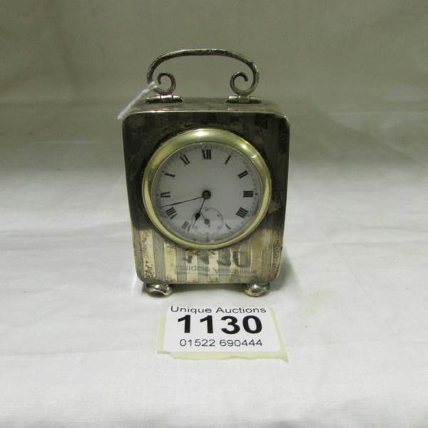 A small silver cased clock, spring a/f