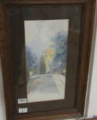 A framed and glazed Edwardian watercolour of a village street, signed but indistinct