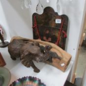 A wooden elephant figure, a carved wood elephant plaque and a lacquered rack