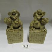 A pair of marble bookends depicting Chinese man on Dog of Foo