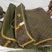 A Louis Vuitton garment bag with hangers