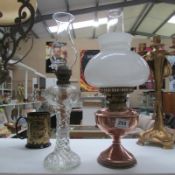 A glass oil lamp with funnel and a copper oil lamp with funnel and shade
