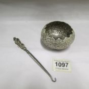 A silver handled button hook and a white metal dish