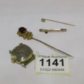 A gold stick pin, gold bar brooch, yellow metal stick pin and a watch head