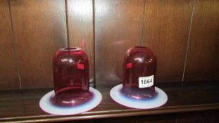 A pair of cranberry glass lamp shades