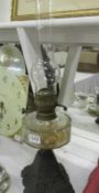 A Victorian oil lamp with cast iron base and glass font