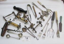 A mixed lot of corkscrews, knife rests, spoons etc