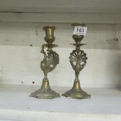 A pair of brass 'Peacock' candlesticks