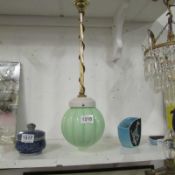 A hanging brass and copper ceiling light with green Art Deco shade